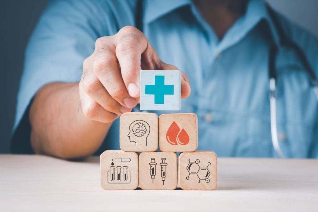 Critical Ways Billing and Invoice Outsourcing Improves Medical Facilities - Healthcare professional hand stack wood block with medical icons, healthcare concepts.