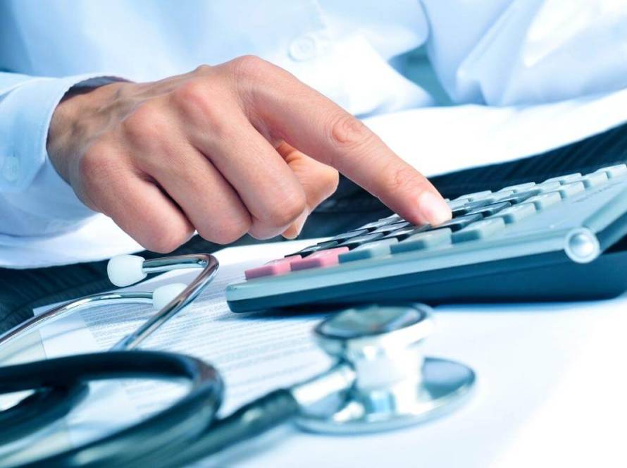 Invoice Outsourcing - Featured Image - Healthcare professiona calculating invoice and billing statement using an electronic calculator. Healthcare, medical billing, invoice process