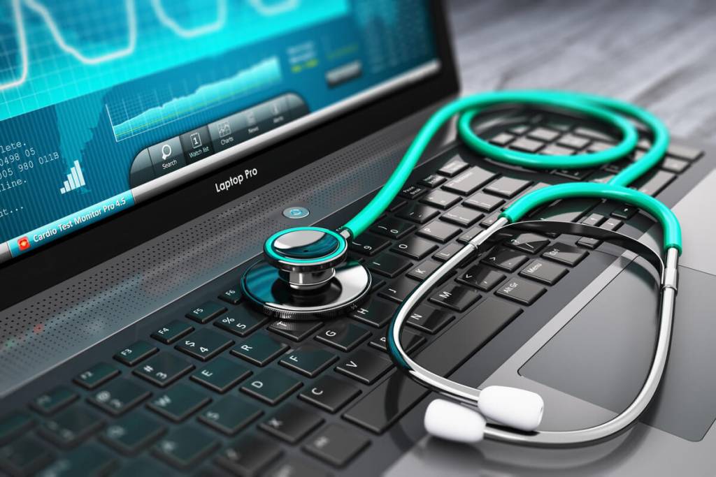 Healthcare BPO Services - Healthcare, medicine and cardiology tool concept: laptop or notebook computer PC with medical cardiologic diagnostic test software on screen and stethoscope on black wooden business office table