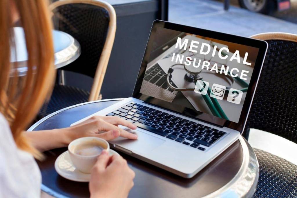 Nurse working on insurance claims on her laptop