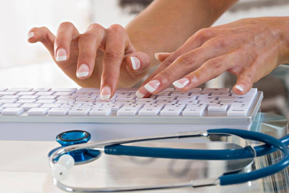 Doctor or nurse typing on a keyboard, encoding medical information