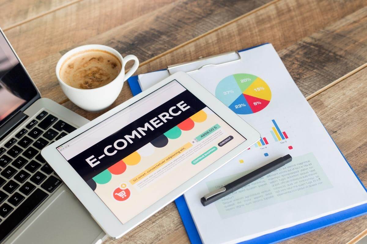 Ecommerce in outsourcing - Ecommerce concept laptop and report on a table.