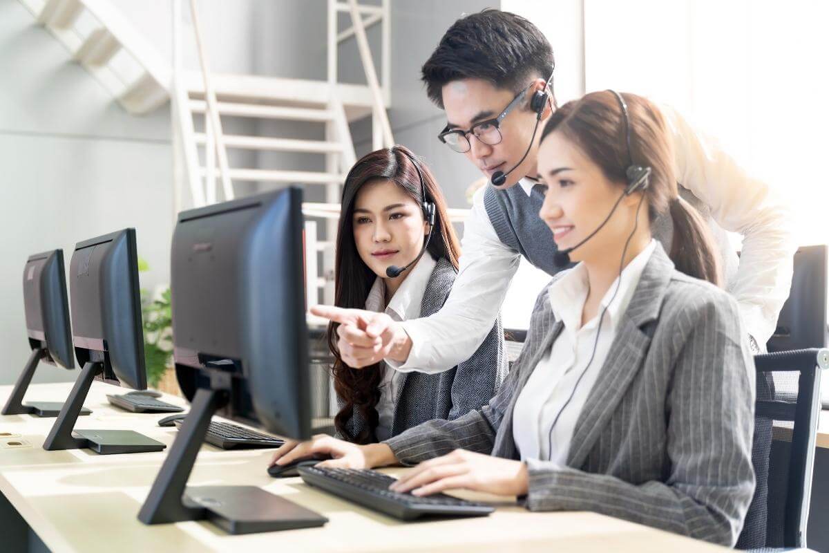 Call center supervisor teaching his team of customer service operators