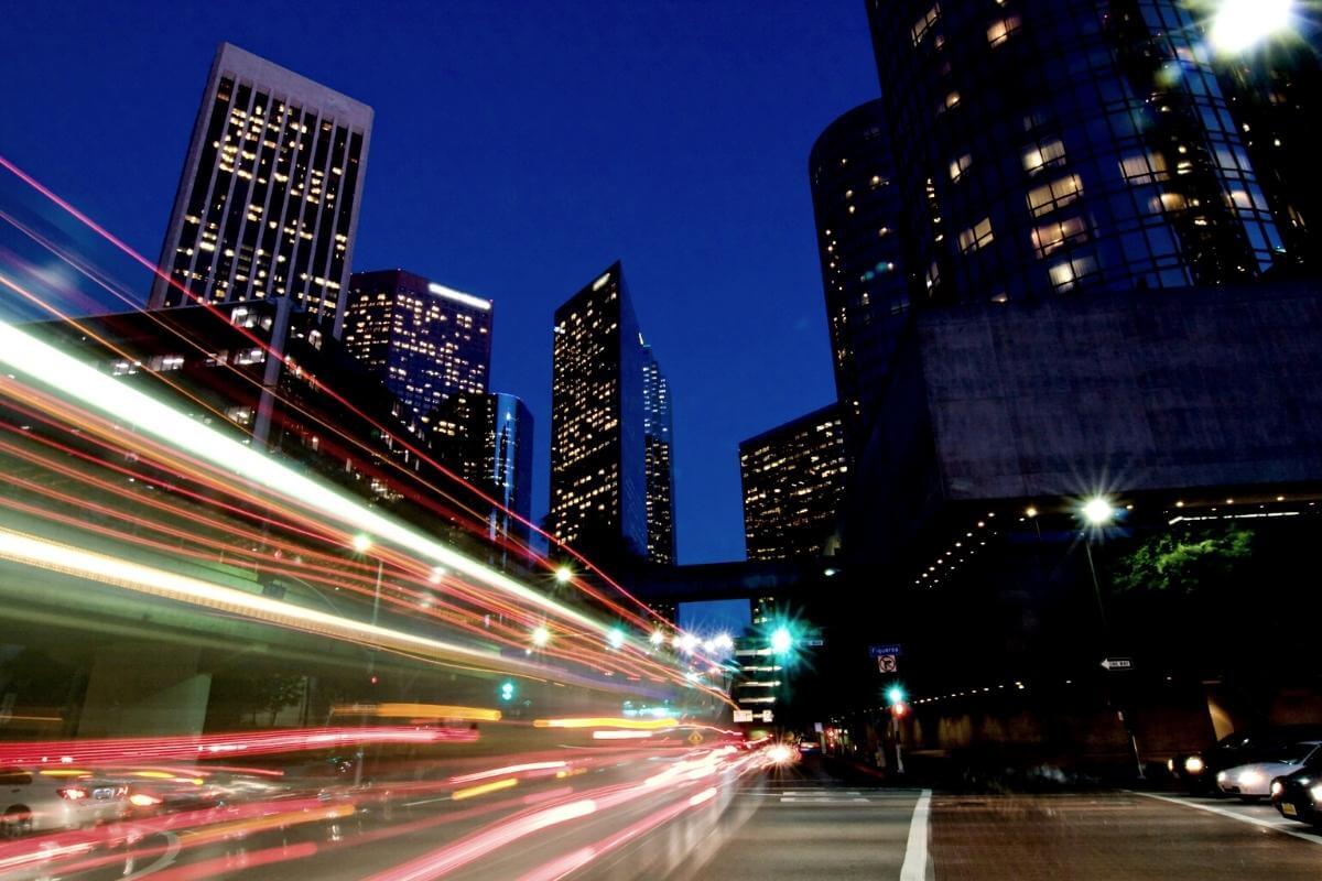 Outsourced Bookkeeping Solutions - Featured image - business growth concept- speed of light across high rise buildings.