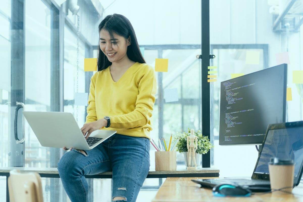 Young female IT support rep working on her laptop