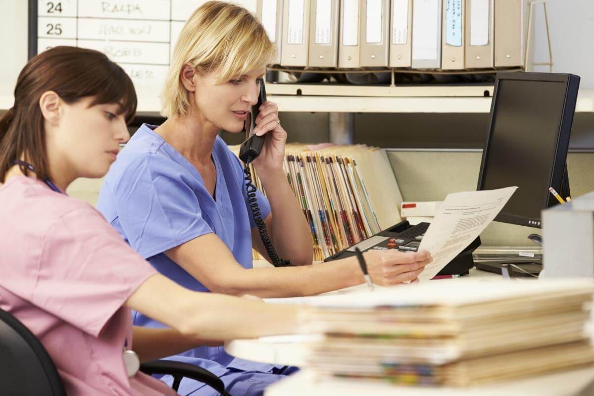 Nurses working on their station calling patients and insurance companies