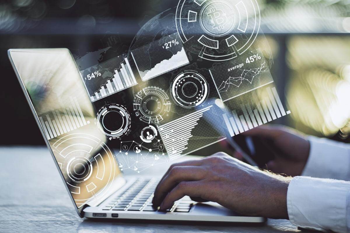 side view of male hands using laptop with abstract business hologram showing data entry, reports and infograph concept