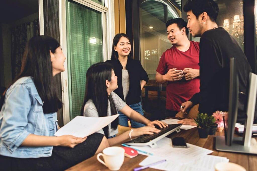 Back Office Outsourcing Services Explained - Asian outsourced team talking having a close meeting in an office