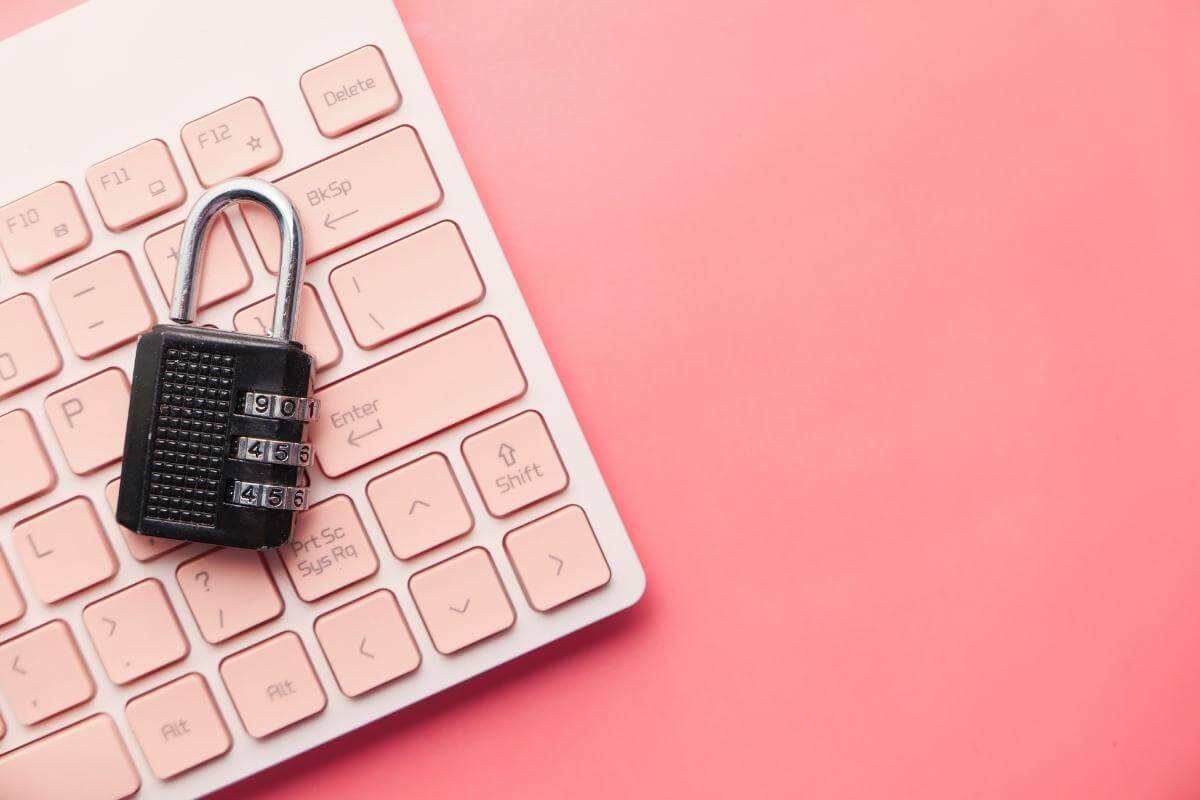 Keyboard and lock on a pink background - concept of data privacy