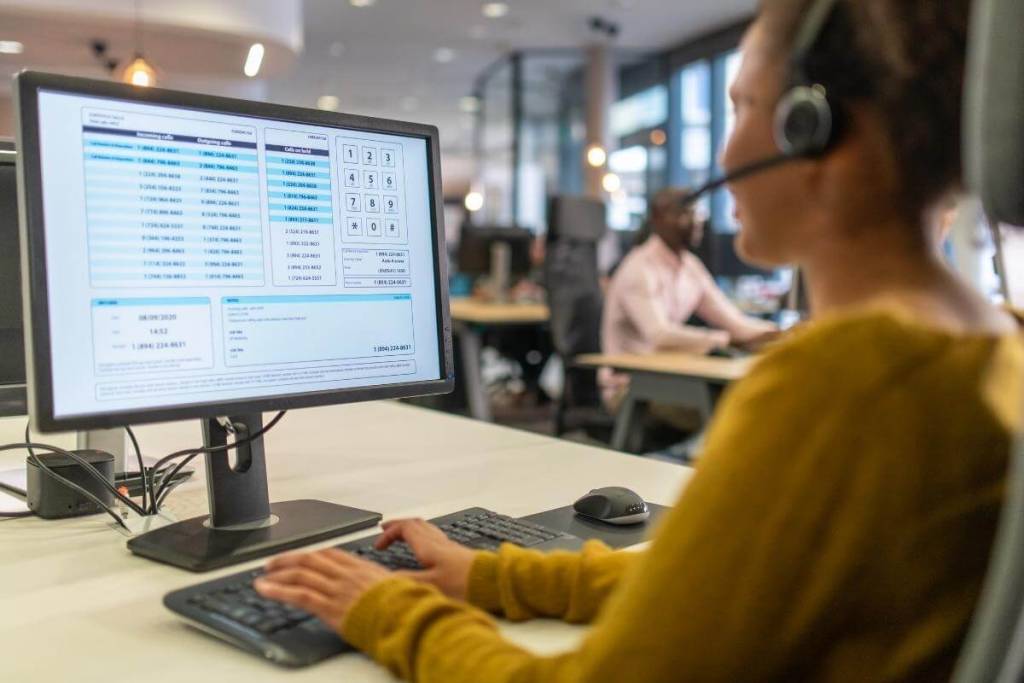 Over the shoulder view of a woman working in a call center as IT Support