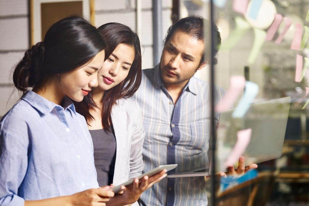 Young Asian corporate executives working together in an office, planning an executing business strategy