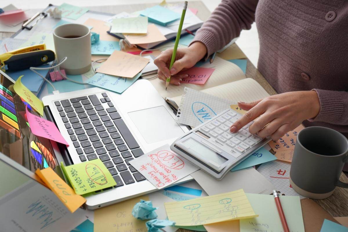  Overwhelmed woman working at a messy office desk