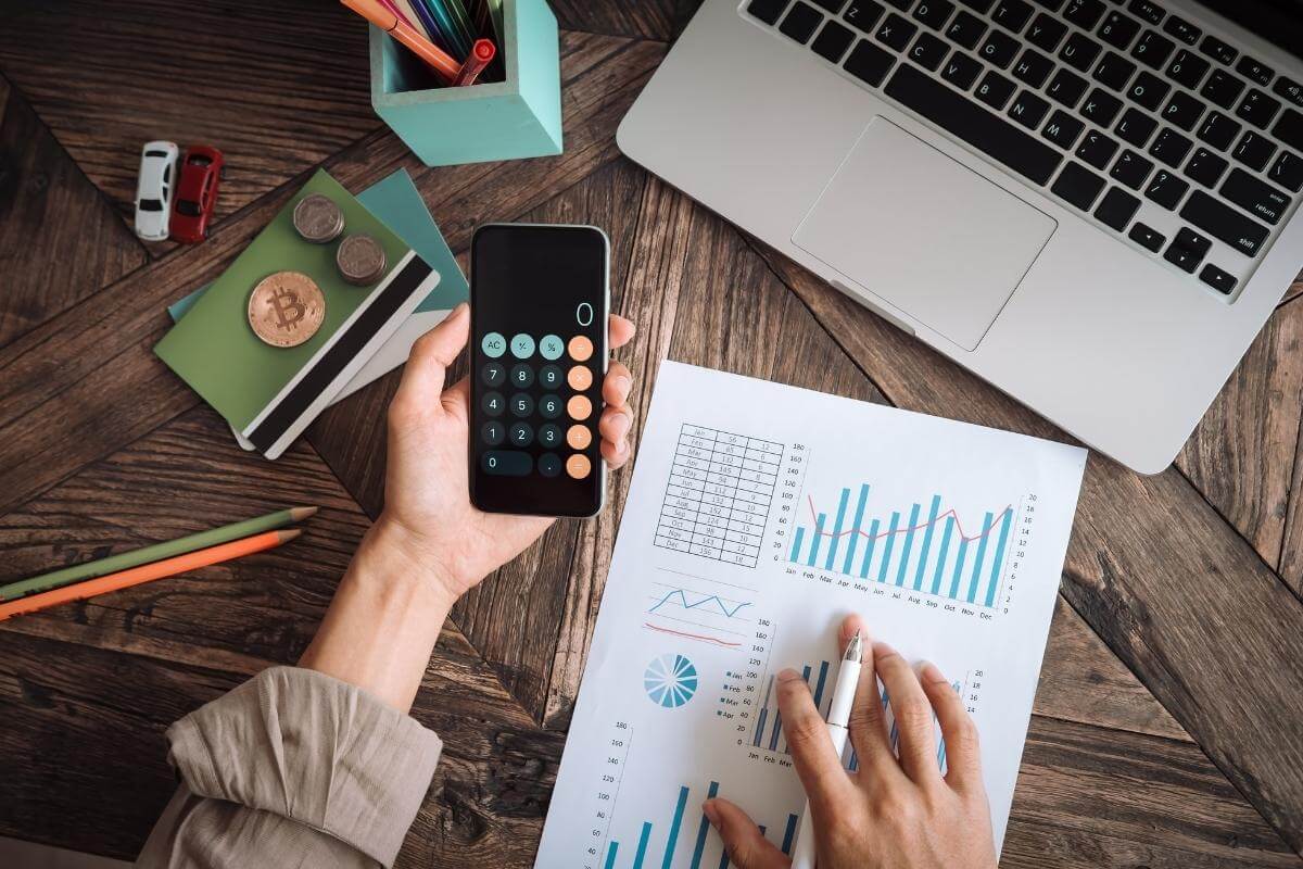  Man working with calculator to calculate numbers, costs, business expenses concept of cost for call center outsourcing. 