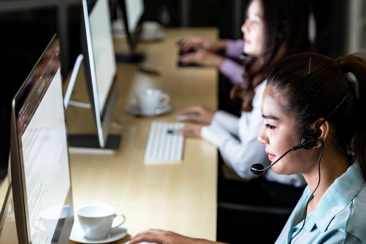 Call center agents working at night. Asian young adults confidence operator colleague team with headsets working in a call center. 