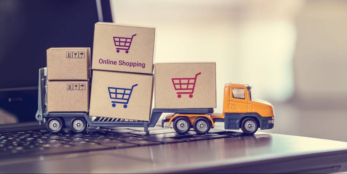 Ecommerce, online shopping and delivery service concept : Boxes with shopping carts on a trailer truck on a laptop, depicts e-commerce impacts the trucking industry that retailer needs fast, low price