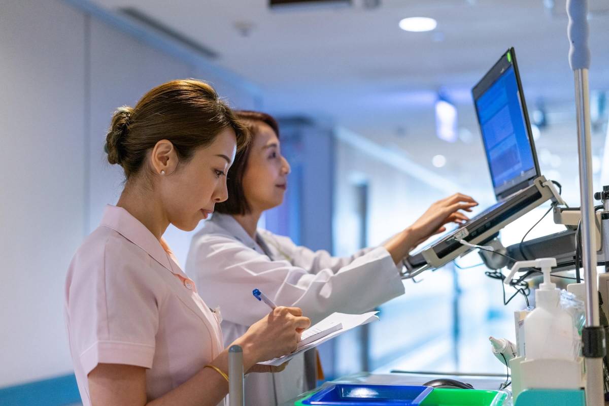 Nurse assisting doctor in writing medical records. 