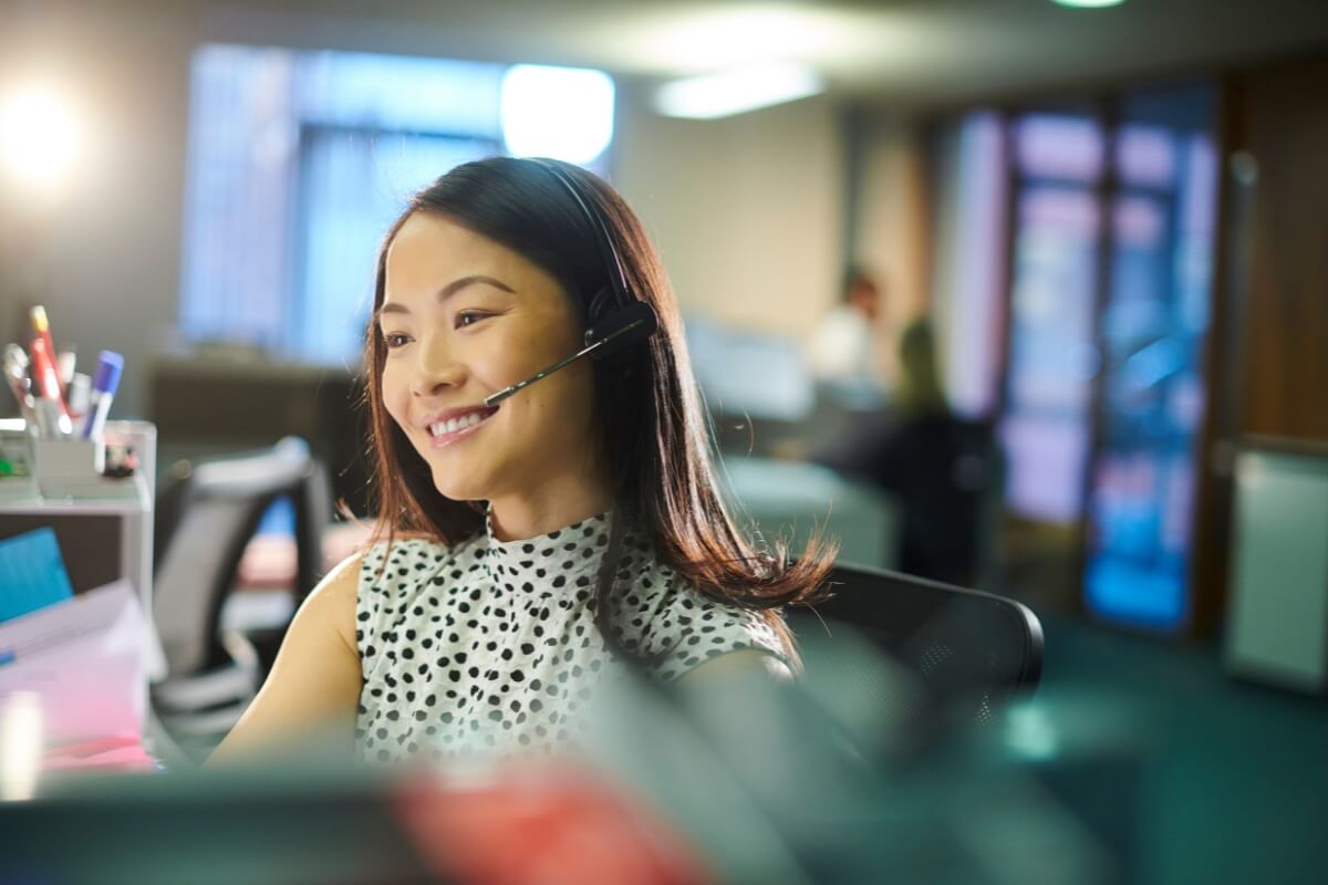 A female customer call center agent talking on the phone with customers