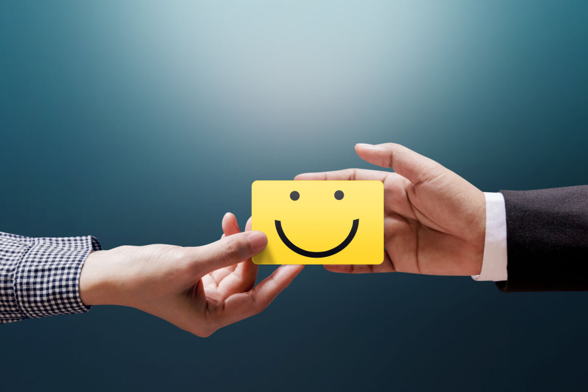 Seven Steps in Outsourcing Customer Communications - Customer Experience Concept, Happy Client Woman giving a Feedback with Happy Smiley Face Card into a Hand of Businessman 