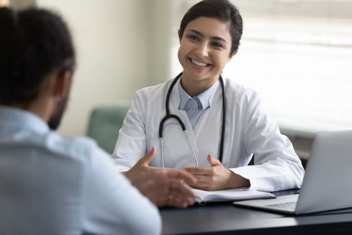 Asian doctor relax while talking to her patient. One of the important benefits of outsourcing is more focus on patient care