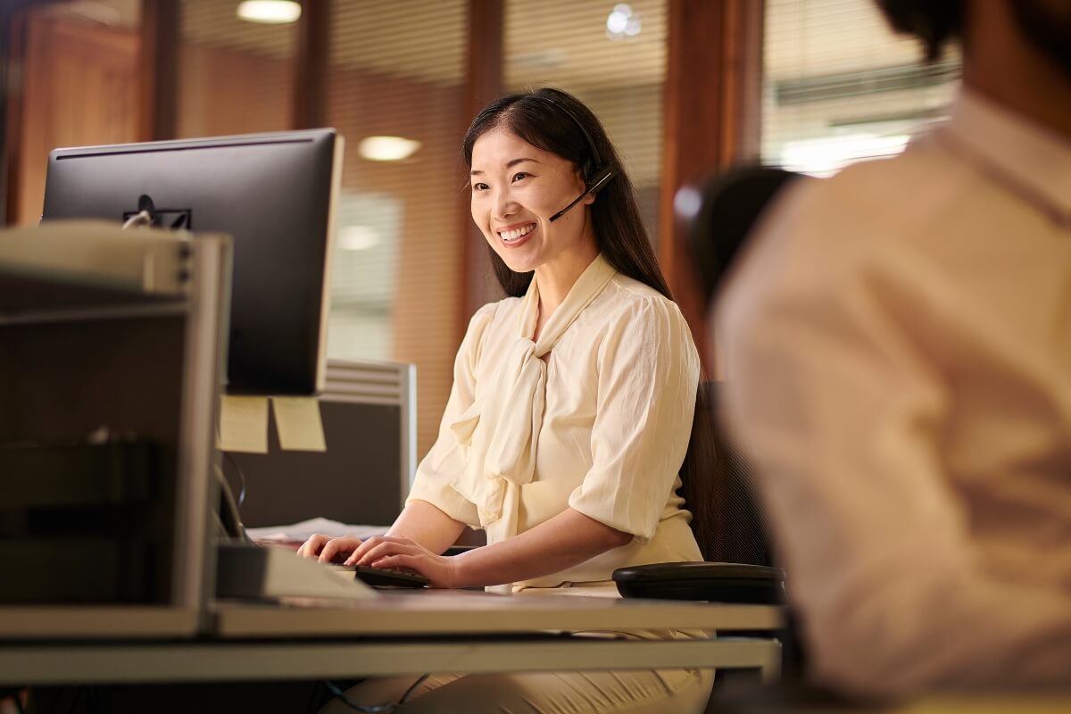 Asian customer service supporting e-commerce store, greeting call with a smile